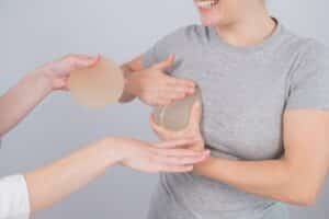Woman holding implants to her chest, consulting with doctor to find the right breast implants for her