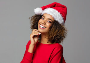 Woman in Santa hat smiling with bright, clear complexion from HydraFacial