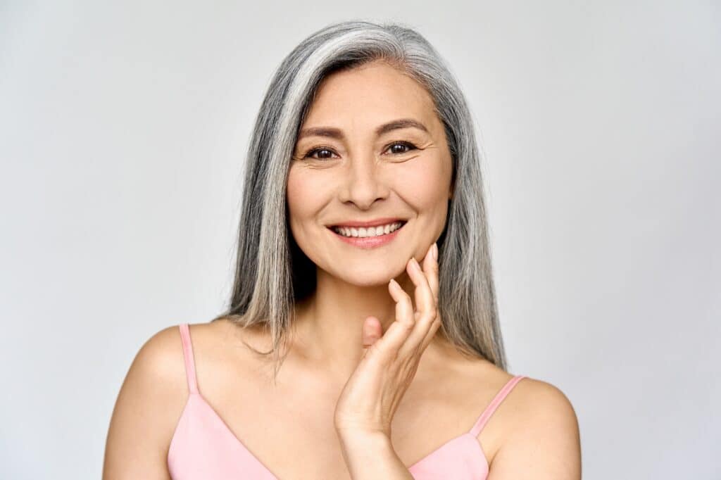 Mature woman touching face after using Empelle Skincare