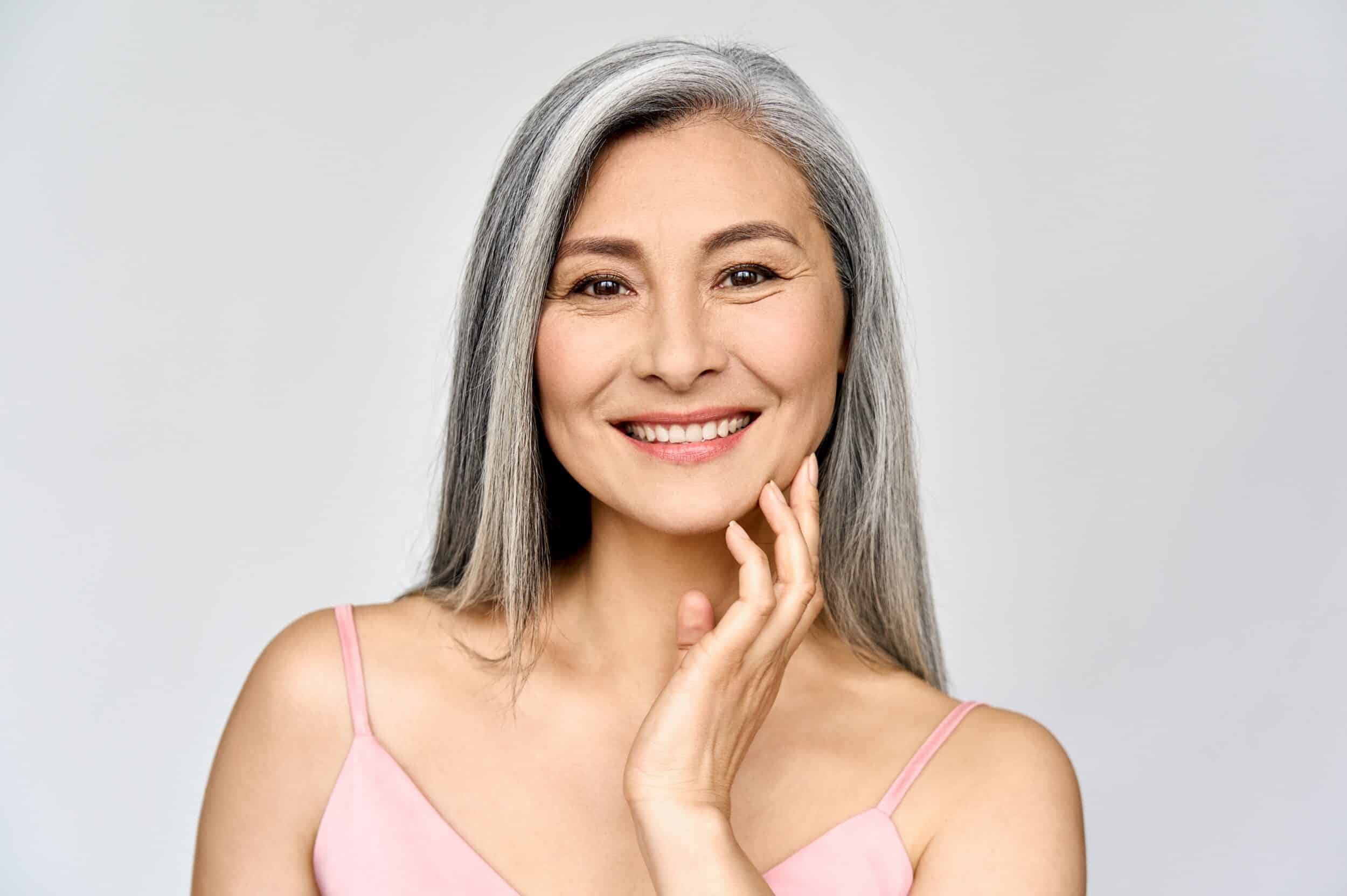 Mature woman touching face after using Empelle Skincare