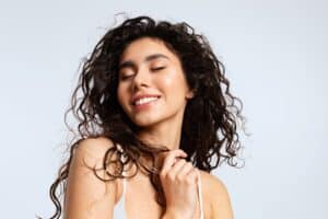 Girl smiling with full, healthy hair from Keravive scalp treatment in East Greenwich, RI